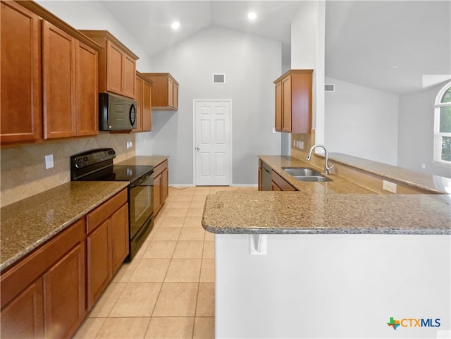 kitchen with sink, black appliances, kitchen peninsula, light stone counters, and vaulted ceiling