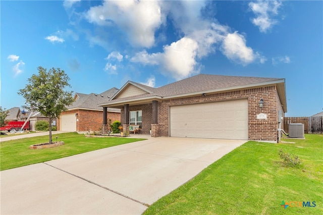 view of front of house featuring central air condition unit, a garage, and a front lawn