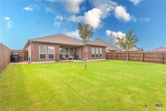 rear view of property featuring a patio area and a lawn