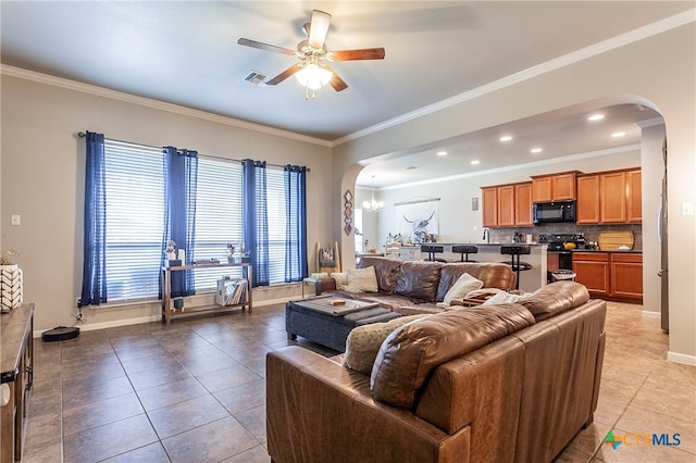 tiled living room featuring ceiling fan with notable chandelier and crown molding