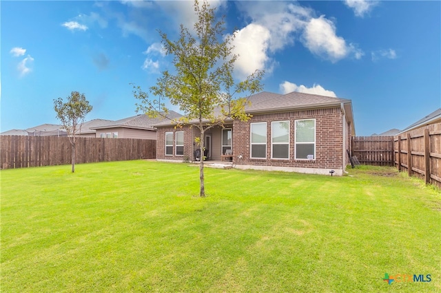 rear view of property with a patio and a yard