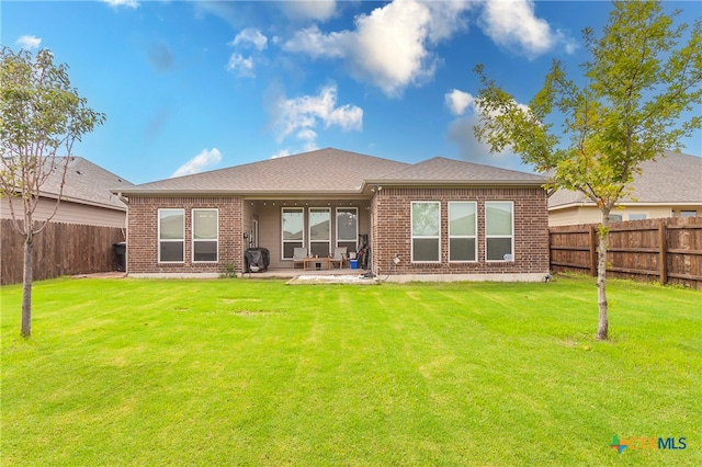 back of house with a yard and a patio area