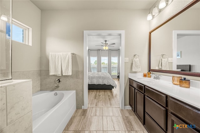 bathroom with a bath, ceiling fan, vanity, and wood-type flooring