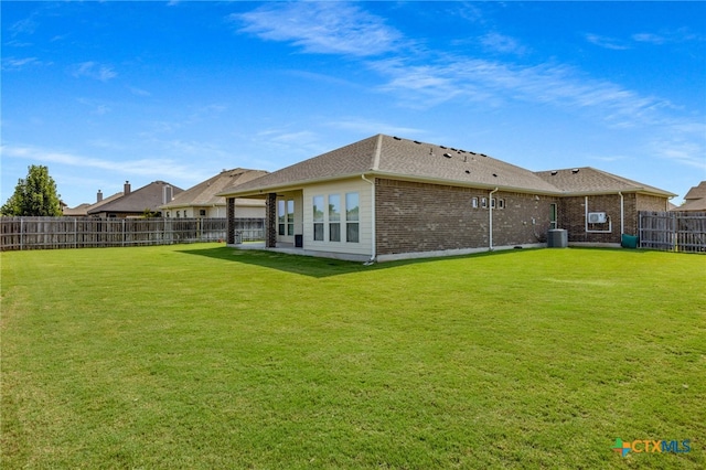 back of property with a lawn and a patio