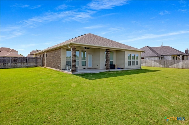 rear view of house with a patio, ceiling fan, and a lawn