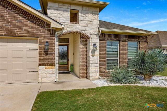 view of exterior entry featuring a garage and a lawn