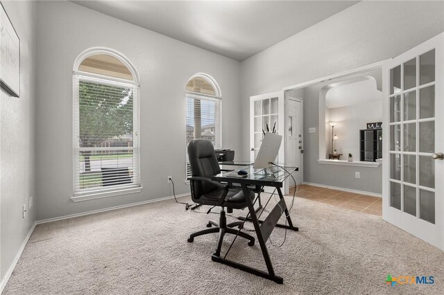 carpeted office with baseboards, french doors, and arched walkways
