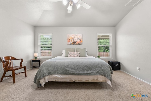 bedroom with ceiling fan, light carpet, vaulted ceiling, and visible vents