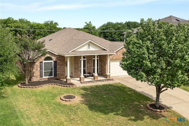 view of front of property featuring a porch, driveway, a garage, brick siding, and a front lawn