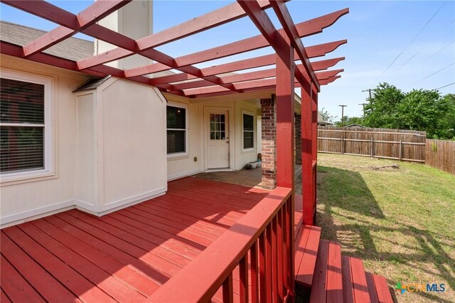 deck featuring a lawn, fence, and a pergola