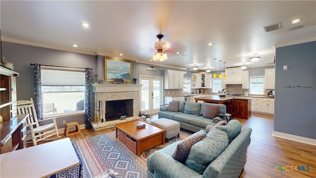 living room with ceiling fan, dark hardwood / wood-style floors, a fireplace, and crown molding