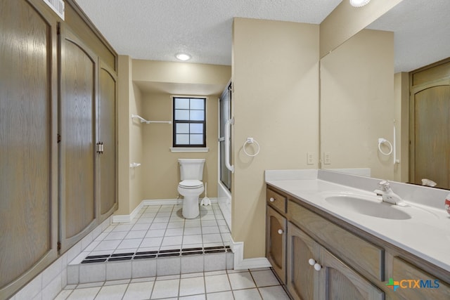 full bathroom featuring shower / bath combination with glass door, vanity, a textured ceiling, tile patterned floors, and toilet