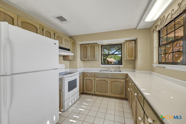 kitchen featuring sink, white appliances, light tile patterned floors, and a textured ceiling