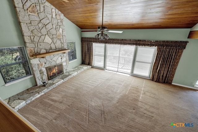 unfurnished living room featuring wood ceiling, light colored carpet, a stone fireplace, and vaulted ceiling