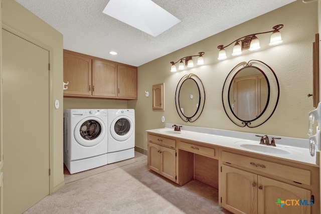 washroom with separate washer and dryer, sink, a textured ceiling, and a skylight