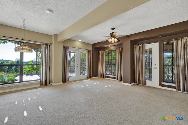 carpeted empty room with ceiling fan, french doors, and a textured ceiling