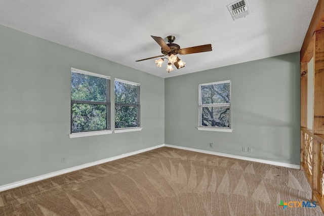 carpeted spare room with a wealth of natural light and ceiling fan