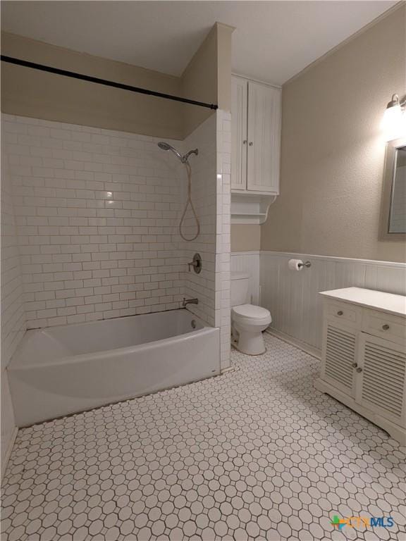 207 W 5th St, Lampasas, TX 76550 - bathroom with vanity, shower / washtub combination, and a wainscoted wall