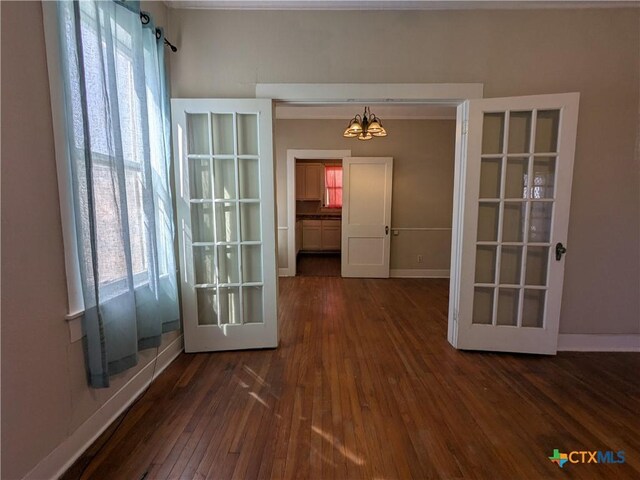 207 W 5th St, Lampasas, TX 76550 - unfurnished room featuring healthy amount of natural light, dark wood finished floors, and a chandelier