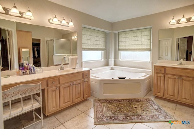 bathroom with a stall shower, a sink, and tile patterned floors