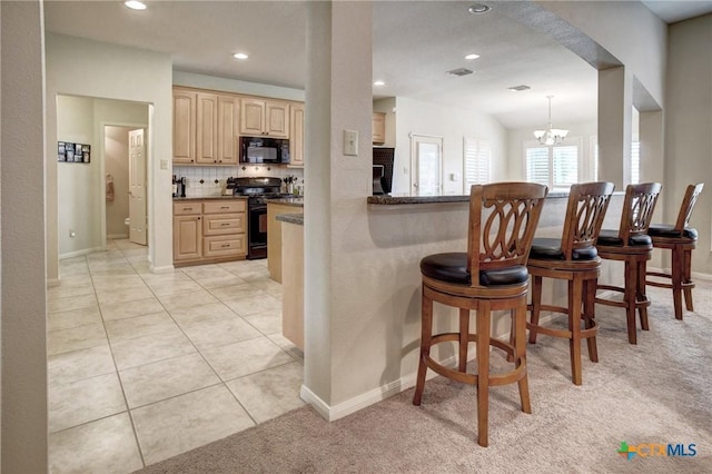 kitchen with visible vents, hanging light fixtures, backsplash, light brown cabinets, and black appliances