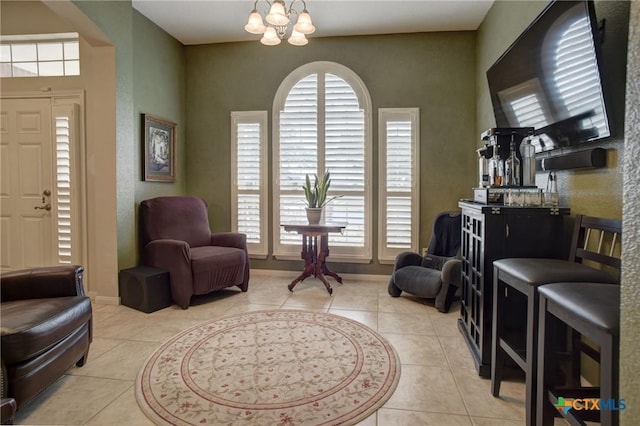 living area with light tile patterned floors, baseboards, and a chandelier