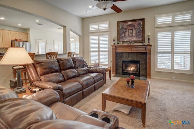 living room with recessed lighting, a high end fireplace, light carpet, ceiling fan, and baseboards