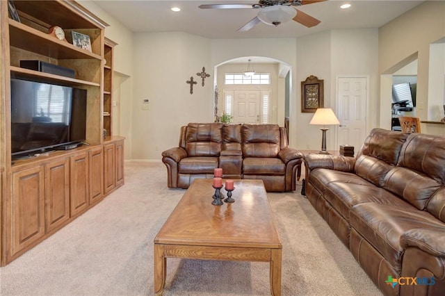 living area with light carpet, ceiling fan, arched walkways, and recessed lighting