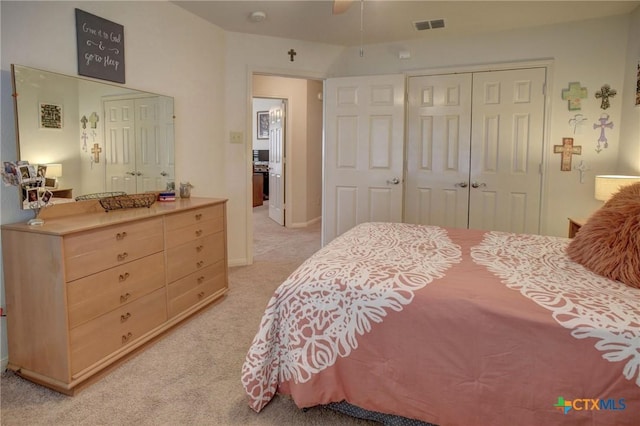 bedroom with light carpet, a closet, and visible vents