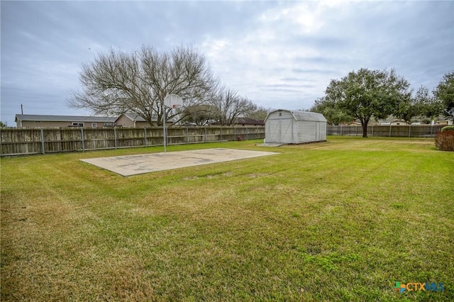 view of yard featuring a fenced backyard, basketball court, a storage shed, an outdoor structure, and a patio area