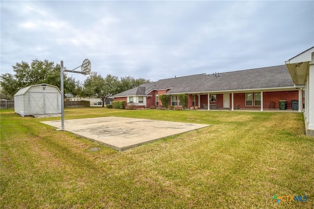 exterior space featuring basketball court, brick siding, an outdoor structure, a lawn, and a storage unit