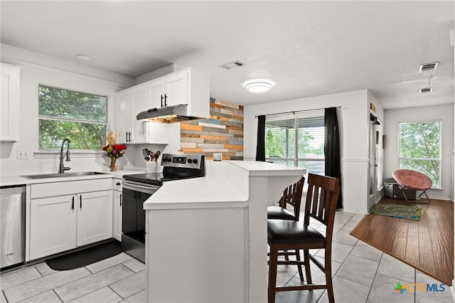 913 Risen Star Ln, Copperas Cove, TX 76522 - kitchen featuring appliances with stainless steel finishes, a sink, a peninsula, a kitchen bar, and light countertops
