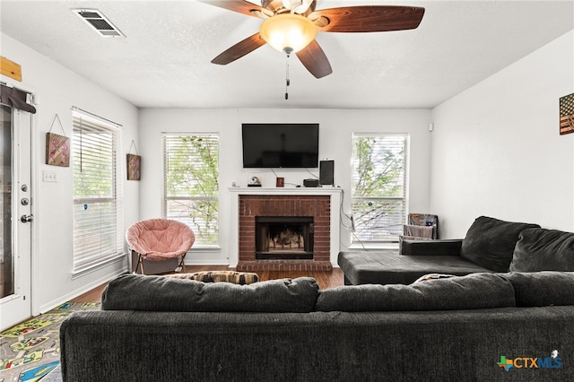 913 Risen Star Ln, Copperas Cove, TX 76522 - living room featuring dark wood-style flooring, healthy amount of natural light, a brick fireplace, and ceiling fan