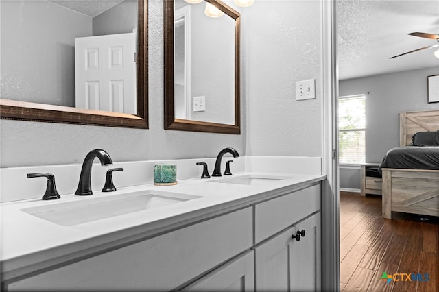 913 Risen Star Ln, Copperas Cove, TX 76522 - bathroom featuring a textured ceiling, a ceiling fan, wood finished floors, ensuite bath, and double vanity