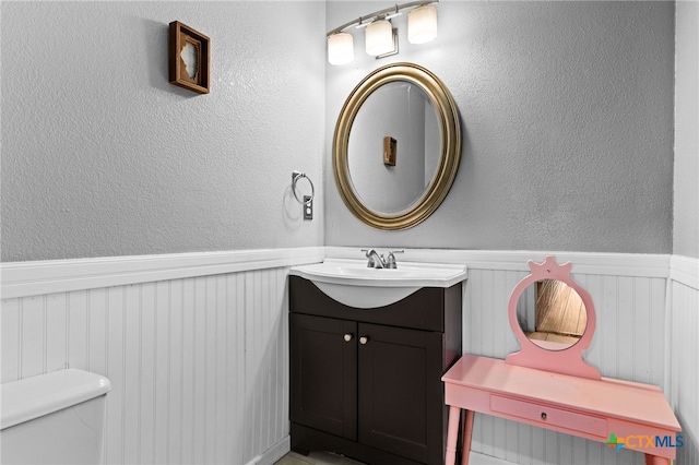 913 Risen Star Ln, Copperas Cove, TX 76522 - bathroom with wainscoting, vanity, a textured wall, and toilet