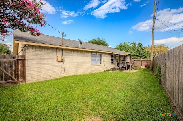 rear view of property featuring a lawn and a patio area