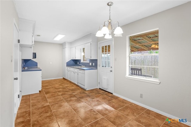 kitchen with pendant lighting, sink, white dishwasher, a notable chandelier, and white cabinets