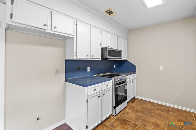 kitchen with backsplash, stainless steel appliances, and white cabinets