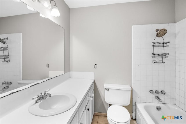 full bathroom featuring tiled shower / bath, vanity, toilet, and tile patterned flooring