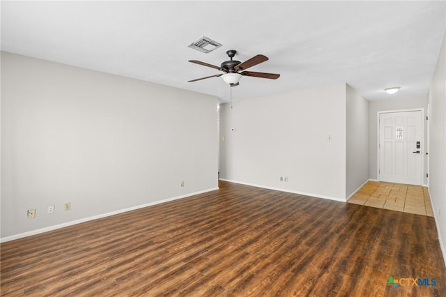 empty room featuring dark hardwood / wood-style flooring and ceiling fan