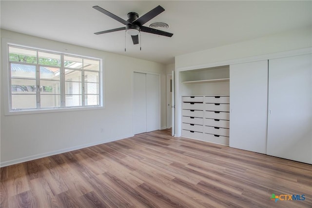 2906 Arroyo Dr, Victoria, TX 77901 - unfurnished bedroom featuring wood finished floors, two closets, and a ceiling fan