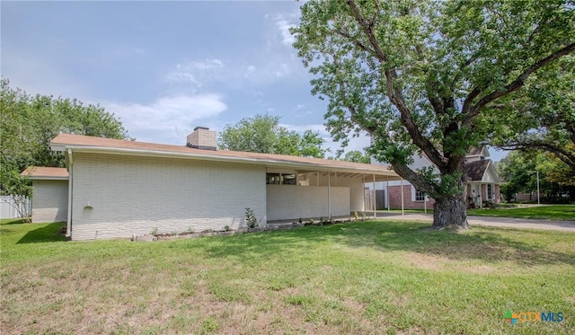 2906 Arroyo Dr, Victoria, TX 77901 - view of property exterior featuring a chimney, a yard, and brick siding