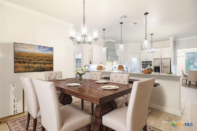dining area featuring visible vents, ornamental molding, and a chandelier