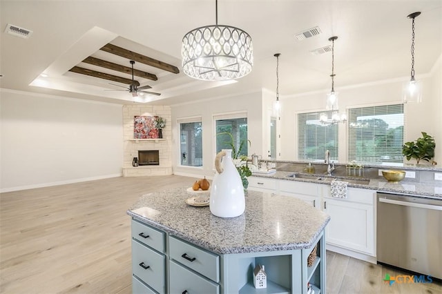 kitchen featuring stainless steel dishwasher, visible vents, a sink, ceiling fan with notable chandelier, and a wealth of natural light