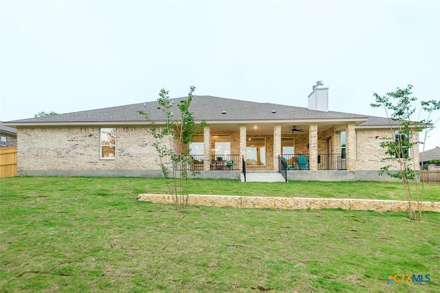back of property featuring brick siding, a lawn, and a patio area