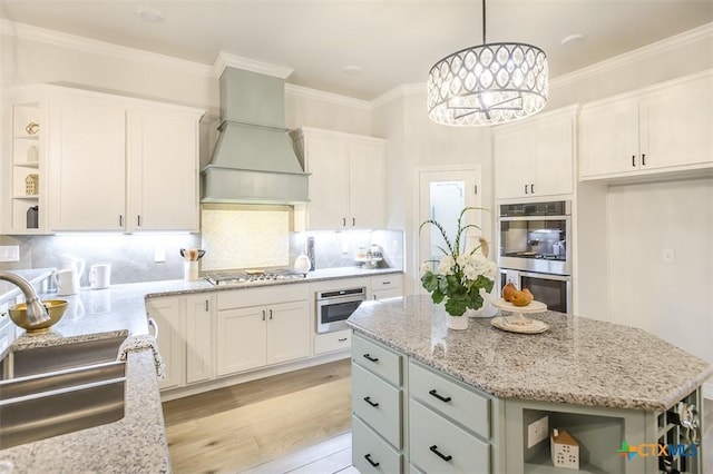 kitchen with a kitchen island, open shelves, a sink, custom exhaust hood, and stainless steel appliances