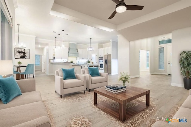 living room featuring baseboards, a ceiling fan, and light wood-type flooring