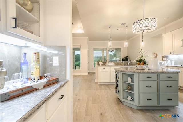 kitchen with crown molding, a notable chandelier, and light wood-type flooring