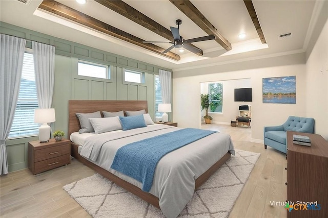 bedroom featuring visible vents, baseboards, light wood-style floors, and beam ceiling