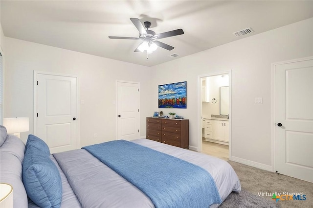 bedroom with connected bathroom, light colored carpet, baseboards, and visible vents